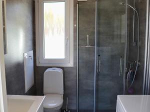 een badkamer met een douche, een toilet en een raam bij Holiday home SÄFFLE IV in Säffle