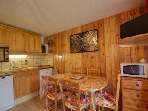 uma cozinha com uma mesa e um micro-ondas em Appartement Morillon Village, 2 pièces, 4 personnes - FR-1-642-69 em Morillon