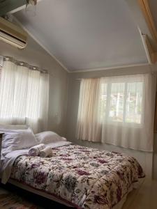 - une chambre avec un grand lit et une fenêtre dans l'établissement Casa da Vila Pousada, à Três Coroas