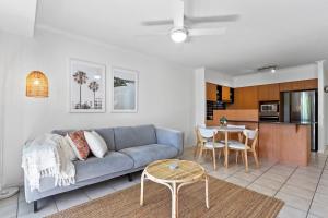 a living room with a blue couch and a table at Seaforth Resort Holiday Apartments in Alexandra Headland