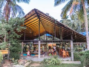 a restaurant with a roof with people sitting at tables at Wonderland Healing Center in Thongsala