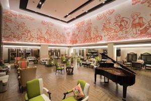 a lobby with a grand piano and tables and chairs at The Heritage Chiang Rai Hotel and Convention - SHA Extra Plus in Chiang Rai