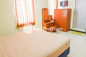 Giường trong phòng chung tại Grand Kembar Hotel Mitra RedDoorz