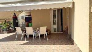 a patio with a table and chairs under an awning at Immaculate 2-Bed Apartment in Glyka Nera