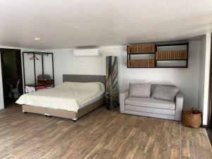 ein Schlafzimmer mit einem Bett und einem Sofa darin in der Unterkunft Loft Mágico en Nativa Resort in Tarcoles