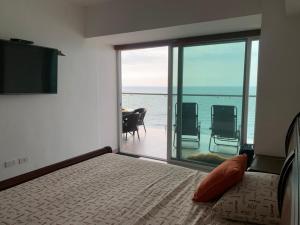 通苏帕Suite de Lujo en Resort Playa Azul, Tonsupa的一间带床的卧室，可欣赏海景