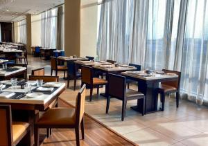 a dining room with tables and chairs and windows at Holiday Inn Chennai OMR IT Expressway, an IHG Hotel in Chennai