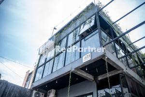 a building with a sign on the side of it at Jabrix Hotel Mitra RedDoorz in Bandung