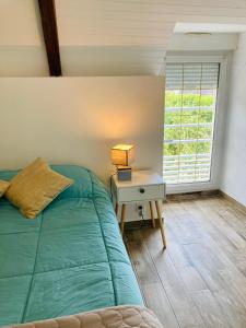 a bedroom with a bed and a desk with a window at Le Clos de Kermadec in Kervignac