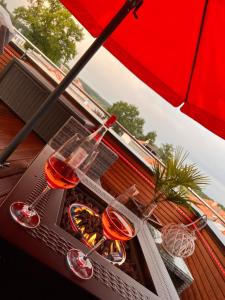 two glasses of wine sitting on a table under an umbrella at Nachtigall in Krakow am See