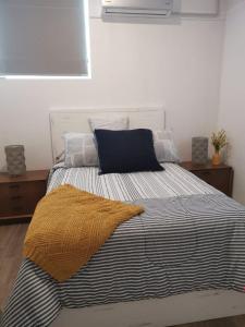 a bedroom with a bed with a yellow blanket on it at TORRE MAR Frente al Malecón in Mazatlán