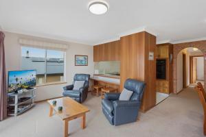 a living room with two chairs and a table at Views on Ballingalla in Narooma