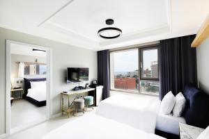 een hotelkamer met een bed en een raam bij Cornerstone Hotel in Seogwipo