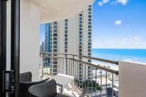 a balcony with chairs and a view of the ocean at Beachcomber Resort - Deluxe Rooms in Gold Coast