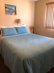 a bedroom with a large bed with blue pillows at Kokanee Glacier Resort in Nelson