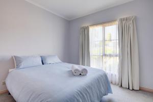 a bedroom with a bed with two towels on it at Avalon Cottage in Port Fairy