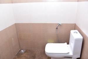 W łazience znajduje się biała toaleta i prysznic. w obiekcie Pauls Retreat Wayanad w mieście Wayanad