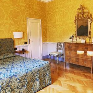 1 dormitorio con 1 cama, vestidor y silla en Palazzo Tucci Residenza d'epoca, en Lucca