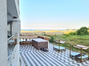 a deck with a table and chairs on a balcony at Aparthotel Happy in Primorsko