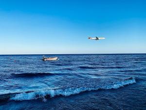 un pequeño barco y un avión en el océano en BALI SUITES 303, en Lárnaca
