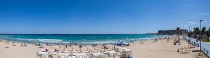 una playa con un montón de sillas y el océano en Cerca del centro de Alicante, en Alicante