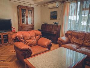 a living room with two leather chairs and a television at Apartment on Tumanyan Street in Yerevan
