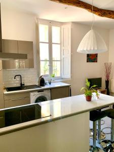 a kitchen with a sink and a dishwasher at La Maison du Courtil, Figue-Miel in Moustiers-Sainte-Marie