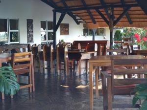 una sala da pranzo con tavoli e sedie in legno di Caprivi River Lodge a Katima Mulilo