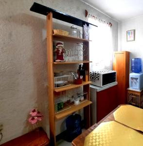 a shelf in a kitchen with a microwave at La Terraza del Pochote in Oaxaca City