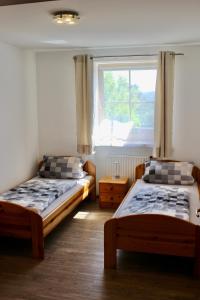 two beds in a room with a window at Ferienwohnungen Seebauer in Nittenau