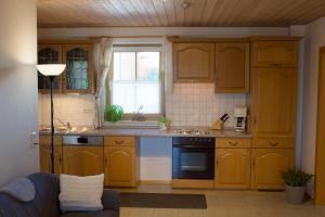 a kitchen with wooden cabinets and a blue couch at Ferienwohnungen Seebauer in Nittenau