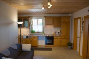 a living room with a couch and a kitchen at Ferienwohnungen Seebauer in Nittenau