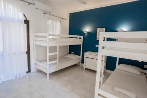 a room with three bunk beds and a blue wall at Villa Aya - 2 Bedroom with Shared Pool in Il-Pergla