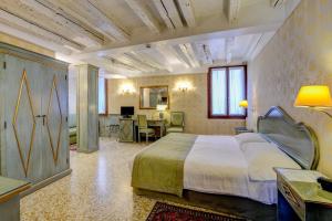 a bedroom with a large bed and a desk at Locanda La Corte in Venice
