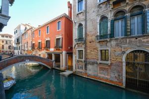 a canal in a city with a bridge and buildings at Locanda La Corte in Venice
