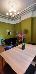 una mesa con un jarrón de flores encima en Histoire de Loire - Savennières sdb partagée, en Saumur