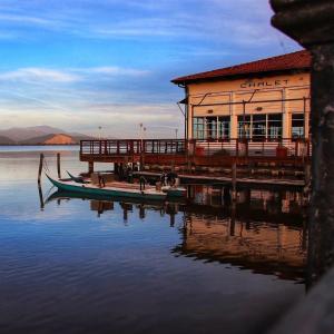 a building on a dock with a boat on the water at Villa Luminosa in Torre del Lago Puccini