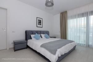 Un dormitorio con una cama grande con almohadas azules. en De Silva, en Mamaia