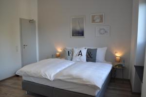 a bedroom with a large bed with white sheets and pillows at Boutique-Hotel "Stilvoll" in Andernach