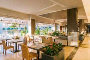 a restaurant with tables and chairs in a building at Ilica Hotel Spa & Wellness Resort in Çeşme