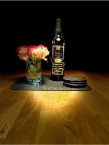 a bottle of whiskey and a vase of flowers on a table at Ferienwohnung Hölzene in Gersfeld