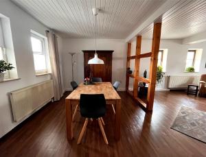 een eetkamer met een houten tafel en stoelen bij Ferienwohnung Hölzene in Gersfeld