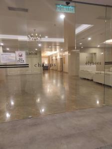 a lobby with a glass wall in a building at Kampar Bonvoy Champs Elysees 4pax Homestay in Kampar