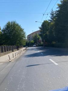 an empty street with a car driving down the road at Medias Cozy Studio in Mediaş