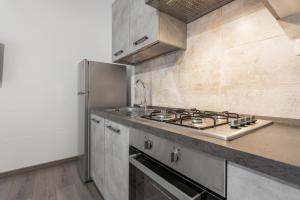 uma cozinha com um fogão e um frigorífico em Casa di Giudy em SantʼAntìoco