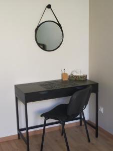 - un bureau noir avec une chaise et un miroir dans l'établissement Gîte Les Demoiselles des Sorgues, à LʼIsle-sur-la-Sorgue