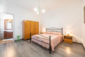 um quarto com uma cama e uma cómoda e uma casa de banho em Casa di Giudy em SantʼAntìoco