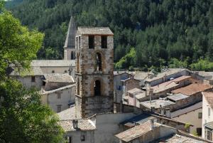 an old building with a clock tower in a town at Maison St Victor in Castellane