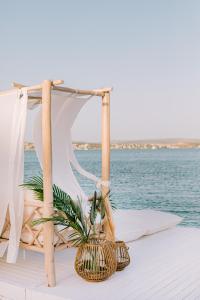 a table with a tent and a plant on a pier at Ilica Hotel Spa & Wellness Resort in Çeşme