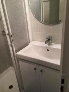 Baño blanco con lavabo y espejo en Appartamento Alpe di Siusi, en Alpe di Siusi